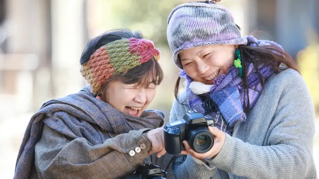 撮影した写真を見せ合う笑顔の高齢者