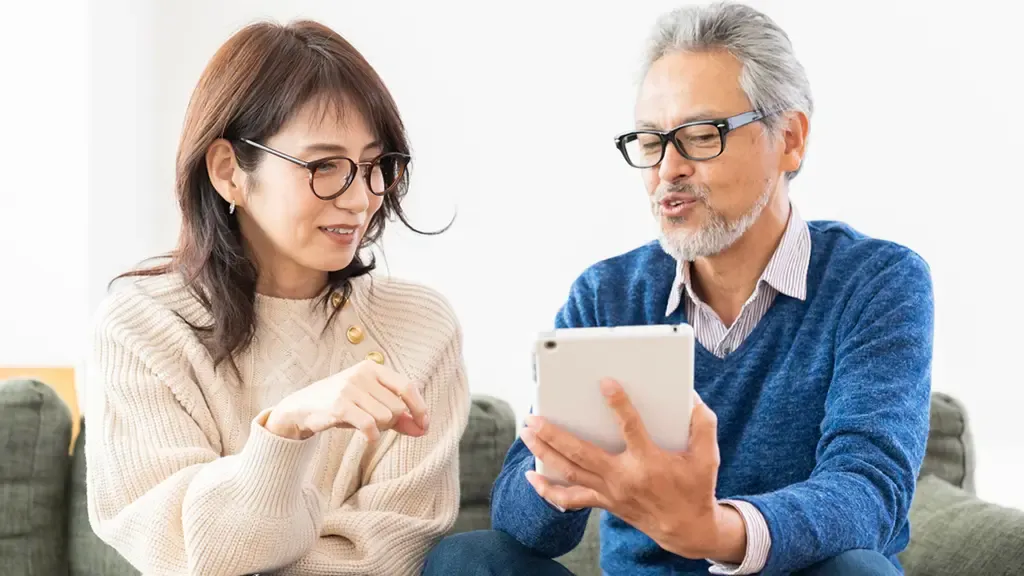 タブレットでゲームをしながら話すふたり